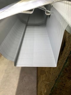 Empty white plastic storage container or tote box with lid partially open, viewed from above